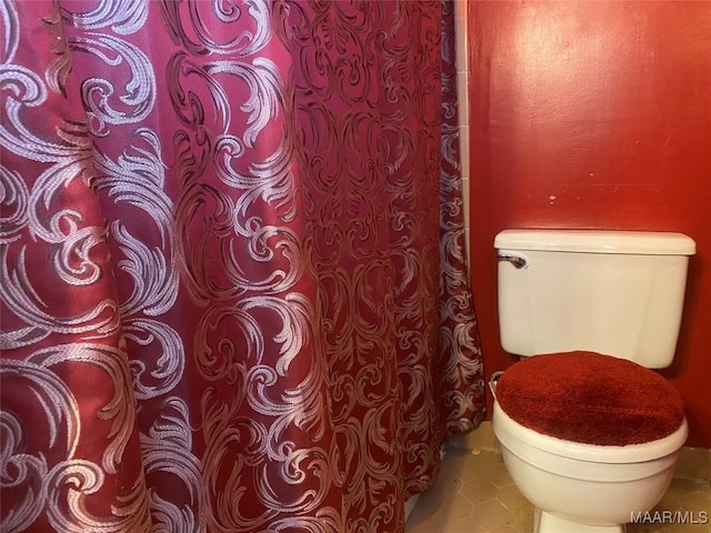 bathroom featuring toilet and tile patterned flooring