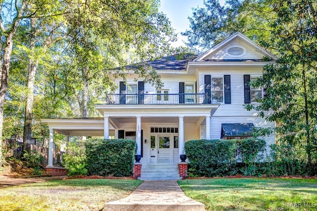 view of front of house with a balcony, a front lawn, and covered porch