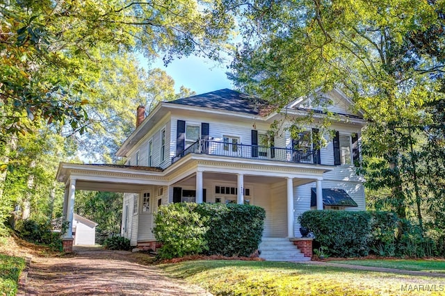 view of front of home with a balcony and a front yard