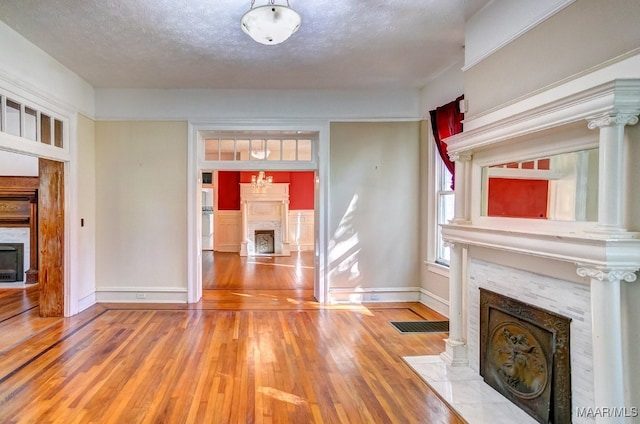 unfurnished living room with hardwood / wood-style floors and a textured ceiling