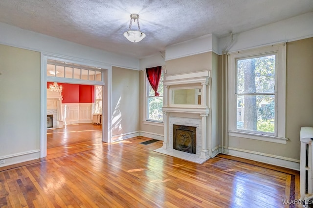 unfurnished living room with a textured ceiling and hardwood / wood-style flooring