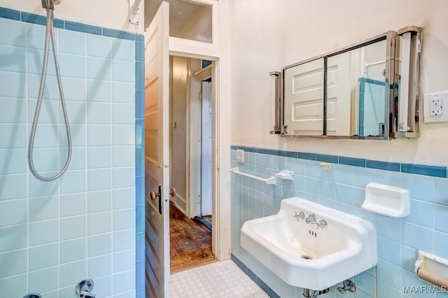 bathroom featuring sink, hardwood / wood-style floors, tile walls, and walk in shower