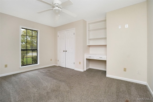 unfurnished bedroom featuring ceiling fan and dark carpet