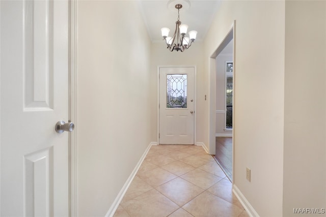 doorway to outside with a notable chandelier and light tile patterned flooring