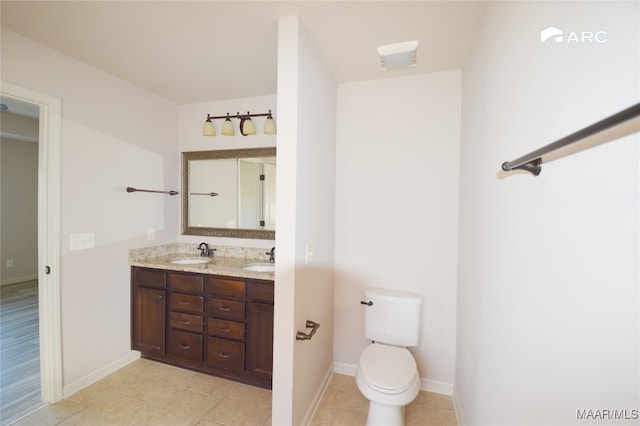 bathroom with tile patterned flooring, vanity, and toilet