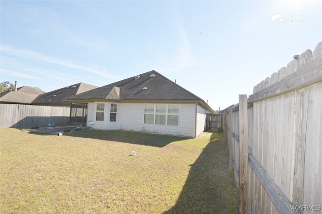 rear view of property featuring a lawn and a patio