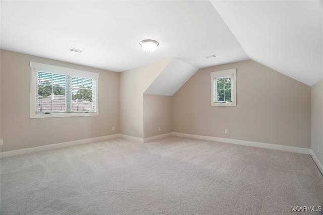 bonus room featuring light carpet and vaulted ceiling