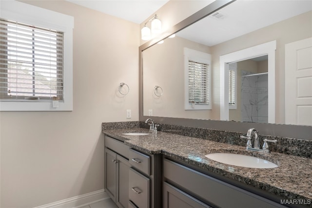 bathroom featuring a tile shower and vanity