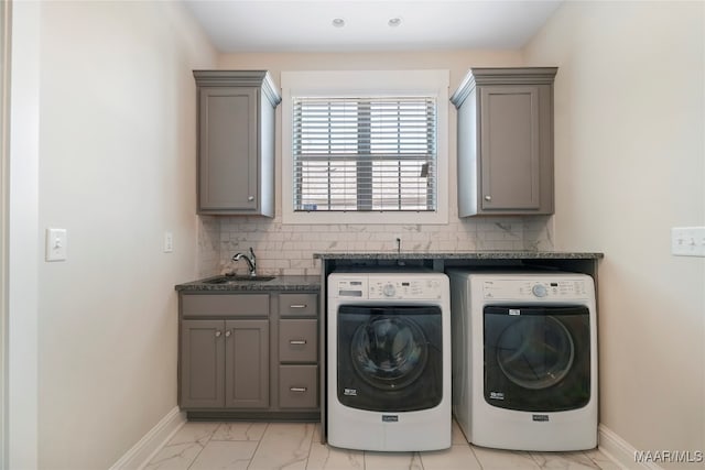 washroom with washing machine and dryer, sink, and cabinets