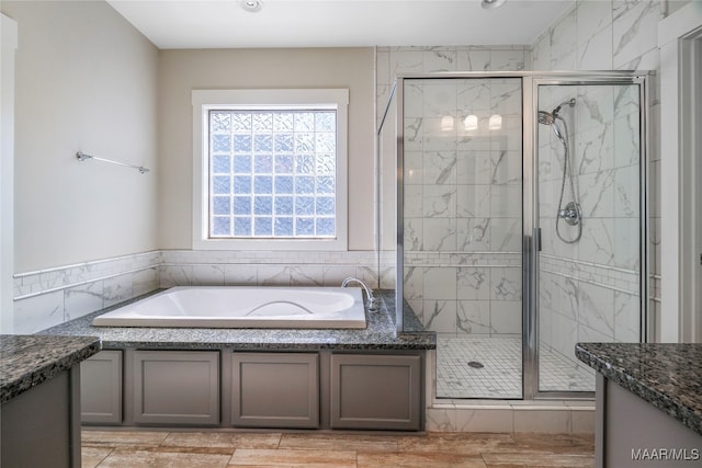 bathroom featuring vanity, tile walls, and independent shower and bath