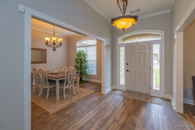 foyer with dark hardwood / wood-style flooring, a notable chandelier, and ornamental molding