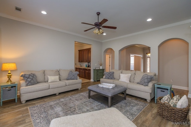 living room with ceiling fan, dark wood-type flooring, and ornamental molding