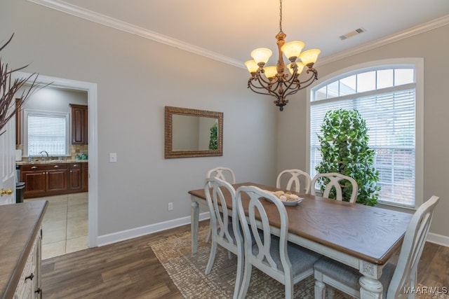 dining area with ornamental molding, an inviting chandelier, dark wood-type flooring, and sink