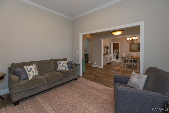 living room featuring ornamental molding, dark wood-type flooring, and a chandelier