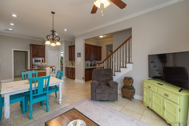 living room with light tile patterned floors, ceiling fan with notable chandelier, and ornamental molding