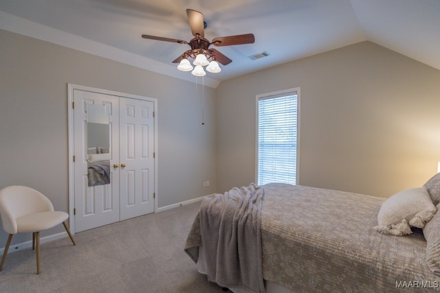 carpeted bedroom with ceiling fan, lofted ceiling, and a closet