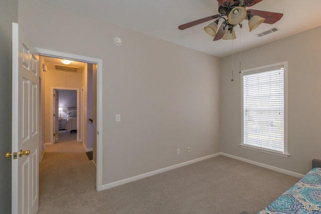 carpeted bedroom featuring ceiling fan and multiple windows