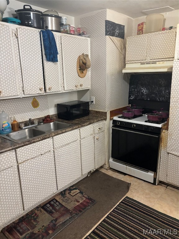 kitchen featuring white cabinetry, gas range gas stove, sink, and light tile patterned floors