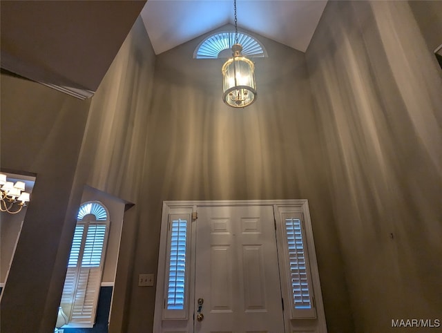 foyer entrance featuring lofted ceiling and an inviting chandelier