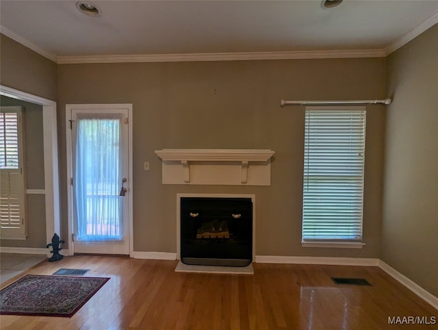 unfurnished living room with hardwood / wood-style floors and crown molding