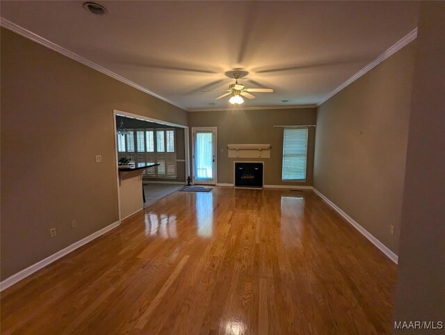 106 Crown Ridge Dr, Selma, AL 36701 - unfurnished living room with ceiling fan, wood finished floors, baseboards, ornamental molding, and a fireplace