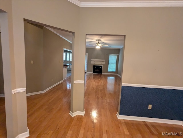 unfurnished living room featuring hardwood / wood-style floors, ceiling fan, and crown molding