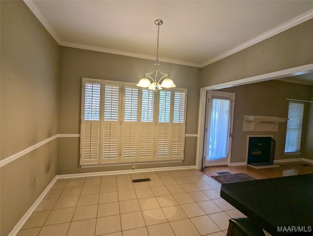 unfurnished dining area featuring a chandelier, light tile patterned floors, and ornamental molding