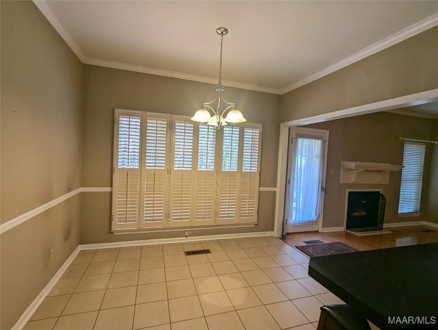 106 Crown Ridge Dr, Selma, AL 36701 - unfurnished dining area featuring a chandelier, tile patterned flooring, crown molding, baseboards, and a fireplace