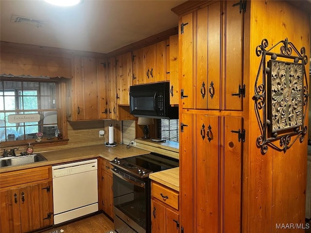 10521 US Highway 31, Hope Hull, AL 36043 - kitchen with white dishwasher, electric stove, black microwave, a sink, and brown cabinetry