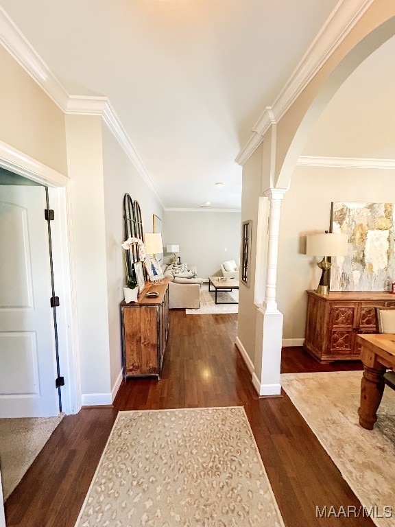 hall with dark hardwood / wood-style floors, ornate columns, and crown molding