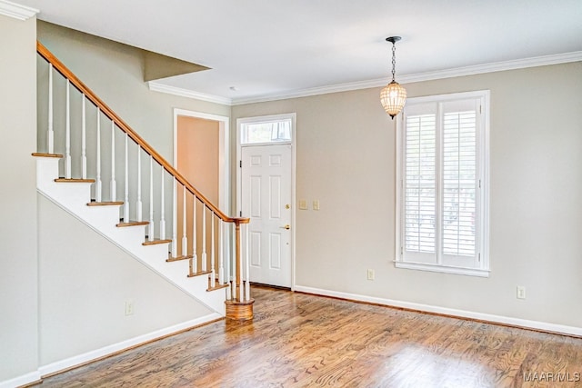 foyer featuring a wealth of natural light, crown molding, and wood finished floors