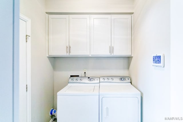 clothes washing area featuring washer and dryer and cabinet space