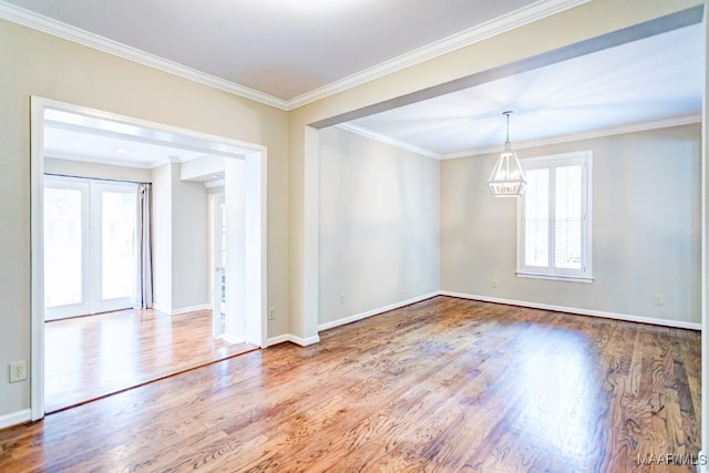 spare room with crown molding, baseboards, wood finished floors, and french doors