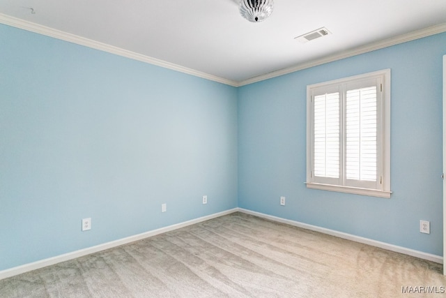 carpeted spare room with ornamental molding, visible vents, and baseboards