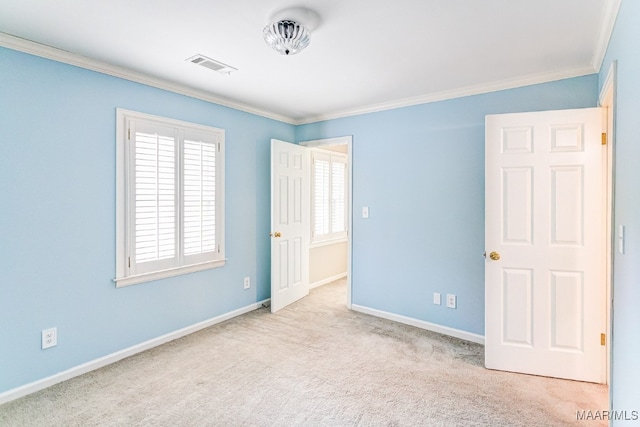 spare room featuring baseboards, visible vents, crown molding, and carpet flooring