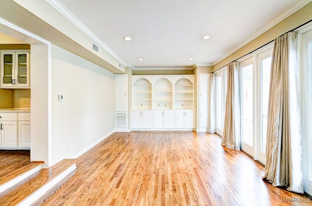 empty room with light wood finished floors, visible vents, crown molding, and recessed lighting