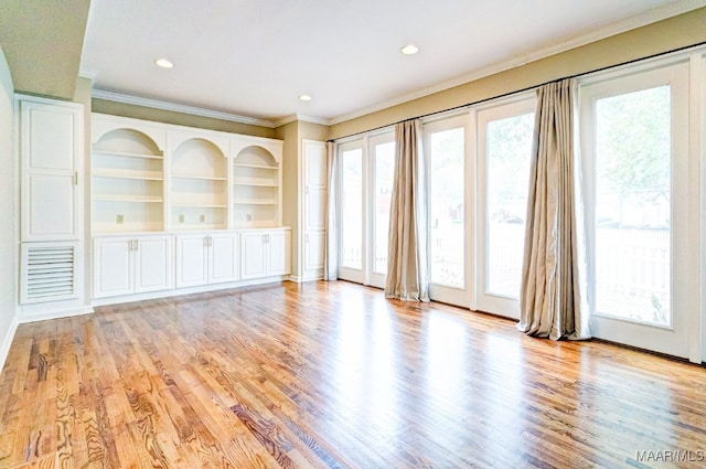 spare room with light wood-style flooring, ornamental molding, built in features, and recessed lighting