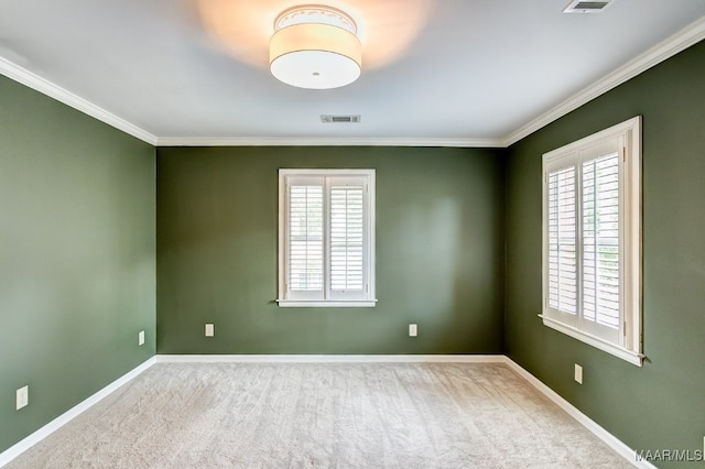 carpeted empty room with ornamental molding, a wealth of natural light, visible vents, and baseboards