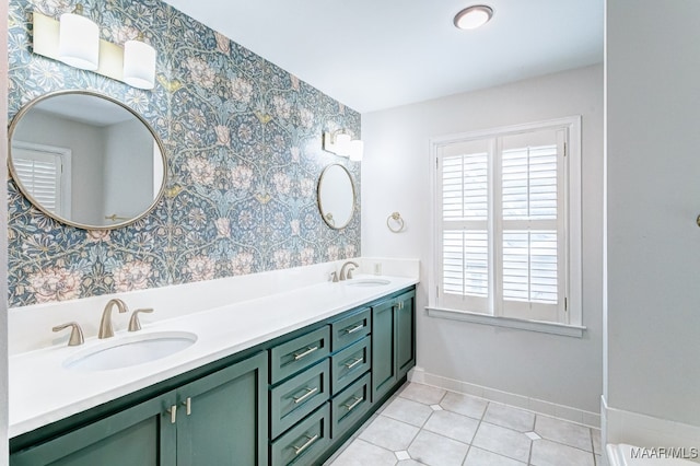 full bathroom featuring double vanity, a sink, baseboards, and wallpapered walls