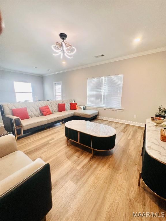 living room featuring ornamental molding and light wood-type flooring