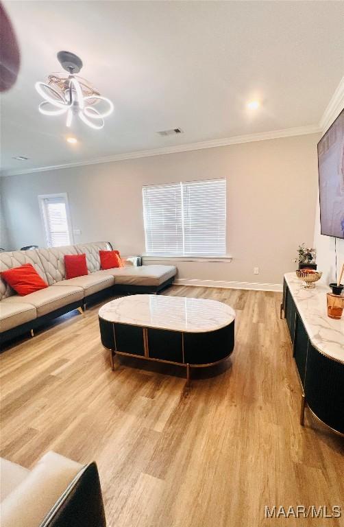 living room featuring light hardwood / wood-style flooring and ornamental molding