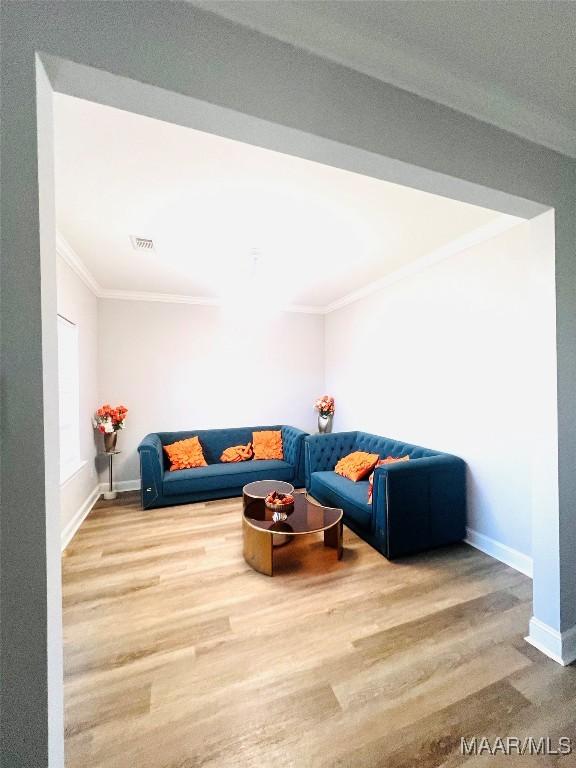 living room with crown molding and hardwood / wood-style floors