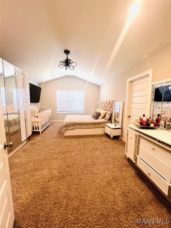 unfurnished bedroom with lofted ceiling and dark carpet