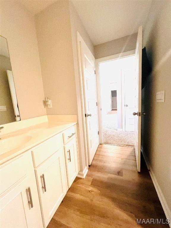 corridor featuring sink and light hardwood / wood-style floors