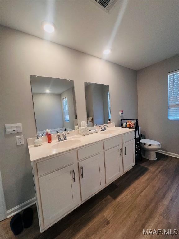 bathroom featuring wood-type flooring, toilet, and vanity