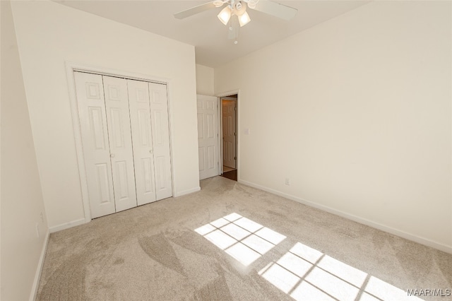 unfurnished bedroom featuring ceiling fan, light colored carpet, and a closet