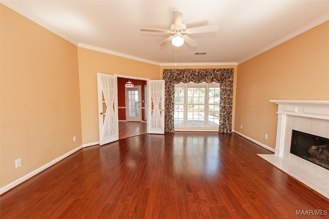 unfurnished living room with a tile fireplace, crown molding, hardwood / wood-style floors, and ceiling fan