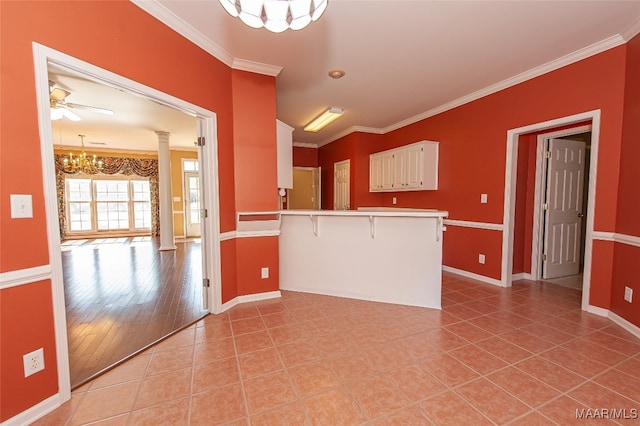 kitchen featuring a kitchen bar, ornamental molding, kitchen peninsula, and light hardwood / wood-style floors