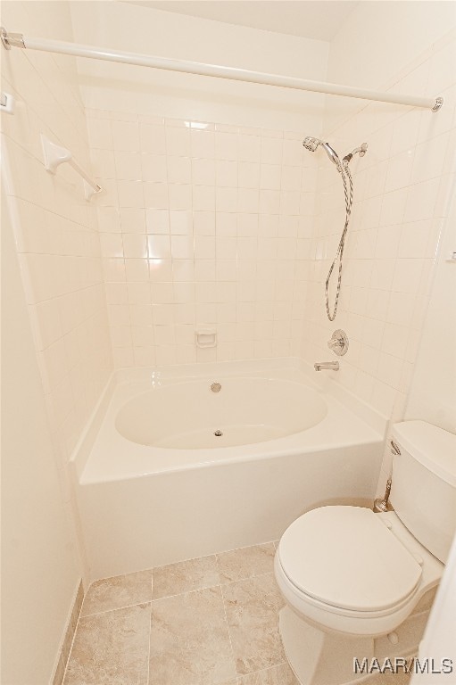 bathroom with toilet and tiled shower / bath