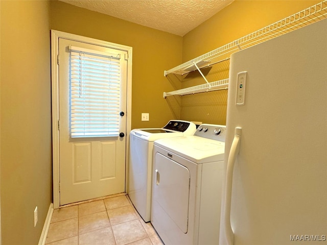 laundry room featuring light tile patterned flooring, independent washer and dryer, and a textured ceiling